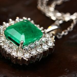 Stunning emerald pendant necklace in white gold with shimmering diamonds, epitomizing luxury and elegance.