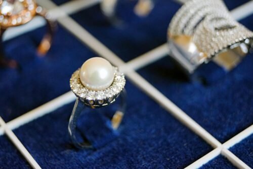 Close-up of a pearl ring with diamonds on a luxurious display.